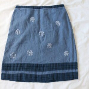 A blue linen skirt hand embroidered with white roses