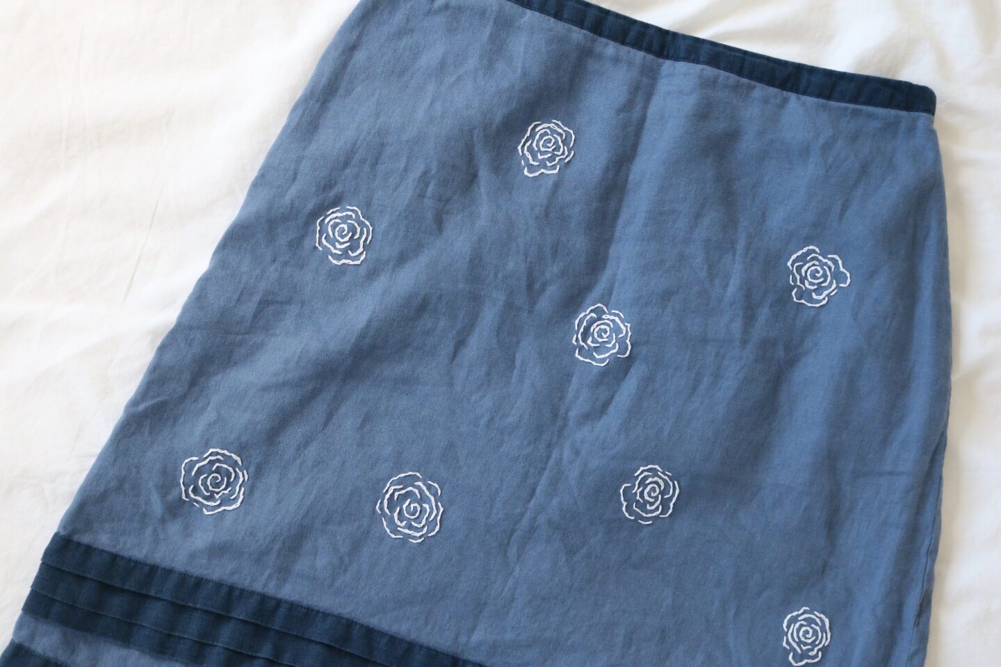 A blue linen skirt hand embroidered with white roses