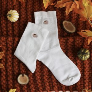 White cotton socks hand embroidered with a mug of hot chocolate, coffee, or tea