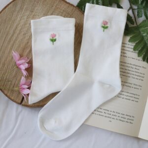White cotton socks hand embroidered with pink tulips and leaves on each sock